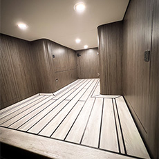 Interior fourgon aménagé cargo area with wood-look plancher and curved armoires under ceiling lights
